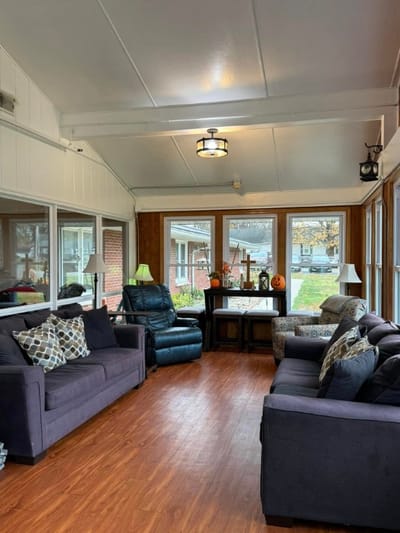 Cozy sunroom with comfortable seating and autumn decor