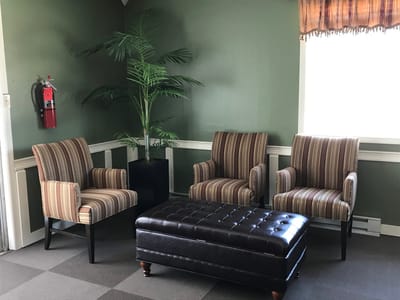 Cozy lounge area with striped chairs and a palm plant
