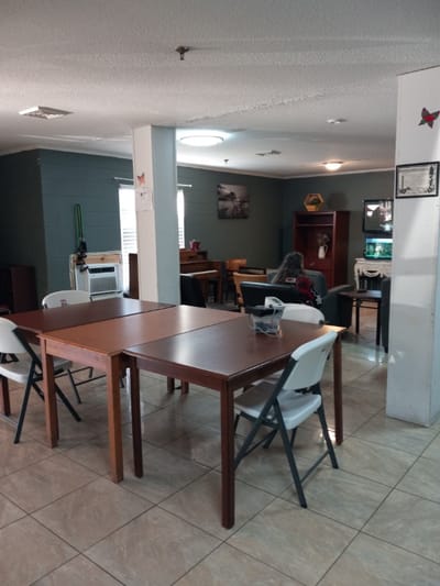 Common area with tables and residents engaged in activities