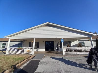 Exterior view of the nursing home with residents entering