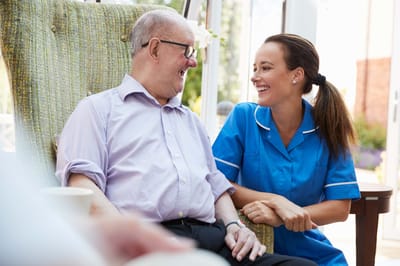 Care staff smiling with a resident in a common area