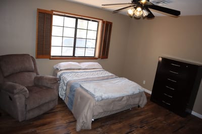 Cozy private resident room with a bed and chair