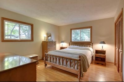Cozy furnished bedroom with a wooden bed and dresser.
