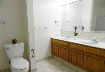 Brightly lit bathroom with double sinks and floral decor