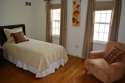 Cozy private resident room with a bed and armchair