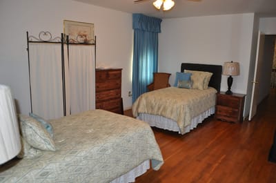 A cozy resident room with two beds and warm decor