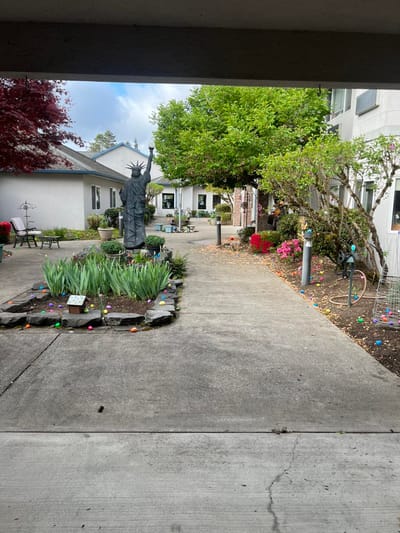 A landscaped outdoor area with a statue and flowers