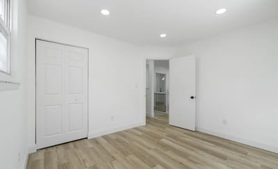 A vacant room with white walls and wooden flooring