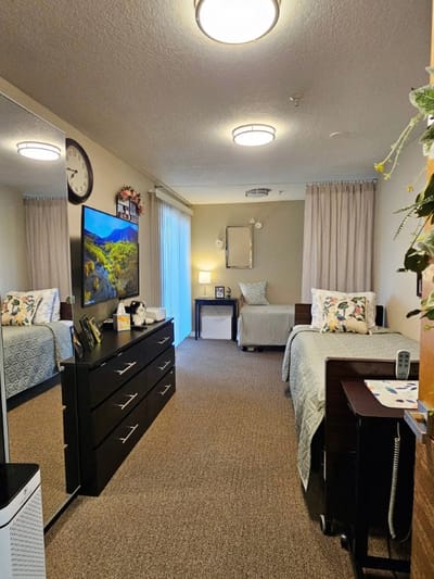 Private resident room with two beds and a TV