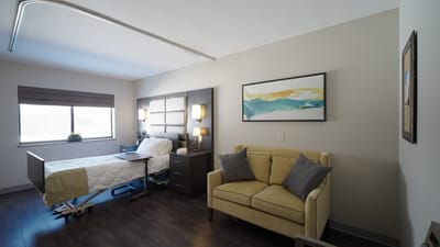 A private resident room with a bed and seating area