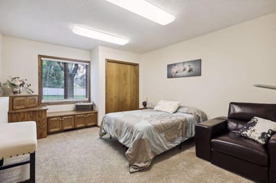 A cozy resident room with a bed and seating area