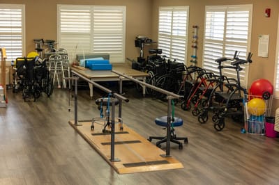 Rehabilitation area with therapy equipment and mobility aids.