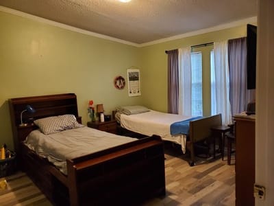 A shared resident room with two beds and natural light