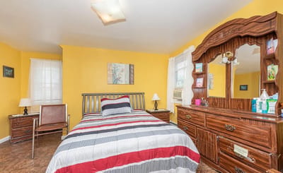A cozy private bedroom with a yellow wall