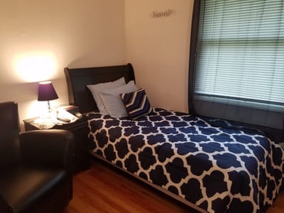 Cozy private room with a bed and bedside lamp