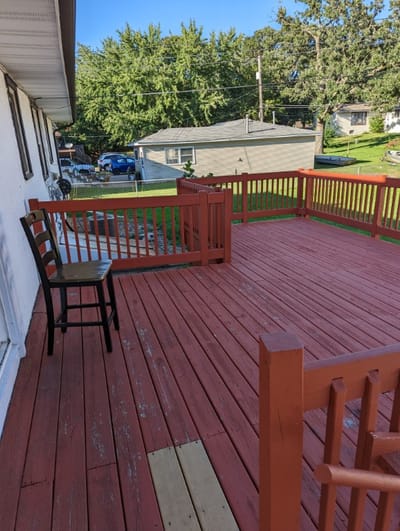 Deck area with a red wooden floor and chair