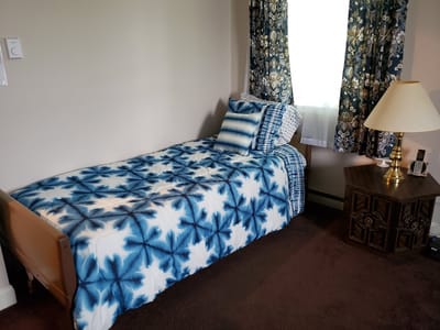A private room with a bed and decorative curtains