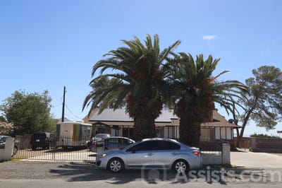 Exterior view of a senior care home with palm trees