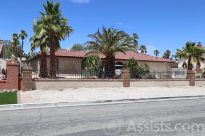 Exterior view of a senior care facility with palm trees