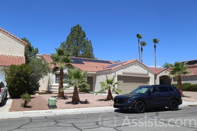 Beachport Villa, assisted living in Las Vegas, NV — Single-story house with palm trees and parked vehicles