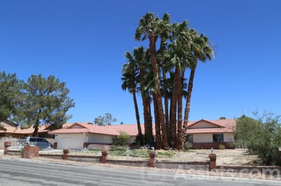 Exterior view of a senior care facility with palm trees
