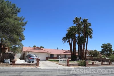 Exterior view of a senior living facility with palm trees
