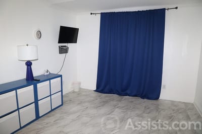 We Care Residential Home, assisted living in Las Vegas, NV — Empty room with a blue curtain and furniture