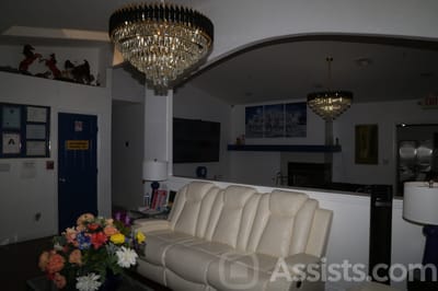 We Care Residential Home, assisted living in Las Vegas, NV — Living room with chandeliers and a white sofa