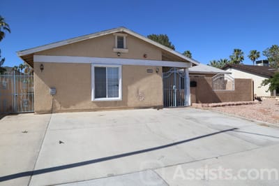 Gentle Spring Care Home, assisted living in Las Vegas, NV — Single-story beige house with gated entrance and driveway