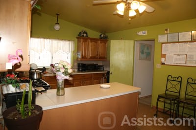 A kitchen area with green walls and wooden cabinets