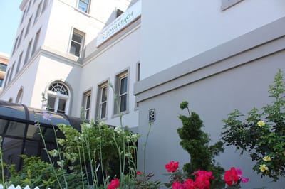Exterior view of Long Beach Assisted Living with garden flowers