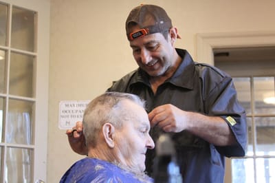 Resident getting a haircut in an activity room