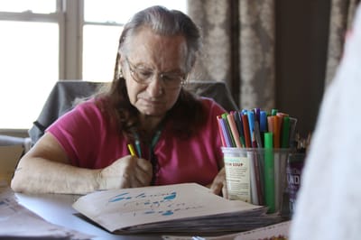 A resident engaged in a creative activity at a table