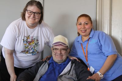 Residents and staff smiling together in a common area