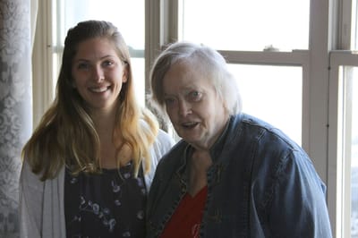 A caregiver with a resident in a light-filled indoor space