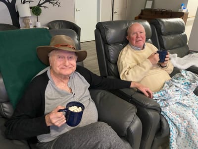 Two senior men enjoying hot drinks together