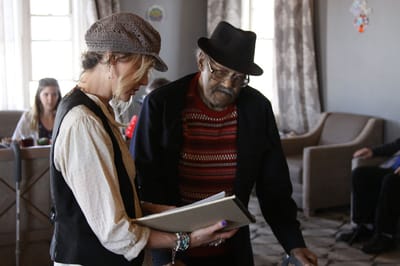 Staff assisting a resident with an activity in the lounge