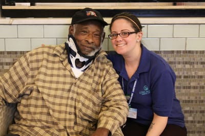 Resident and staff member posing together in a common area