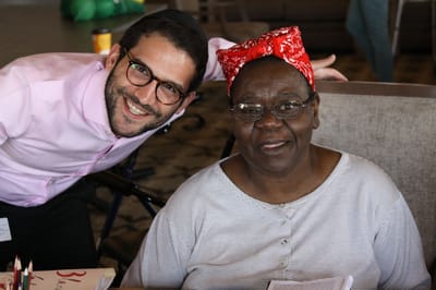 Staff and resident smiling together in the common area