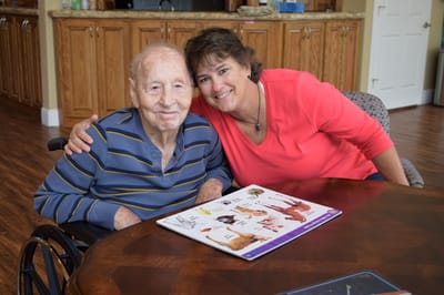 A resident and staff member sharing a moment at a table