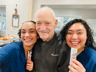 Staff and a resident smiling together in a common area