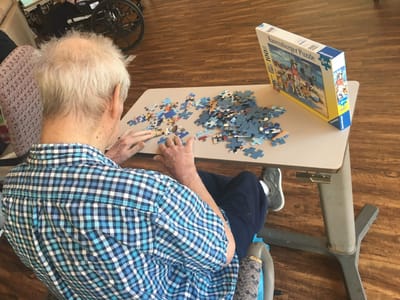 Resident assembling a puzzle in a common area