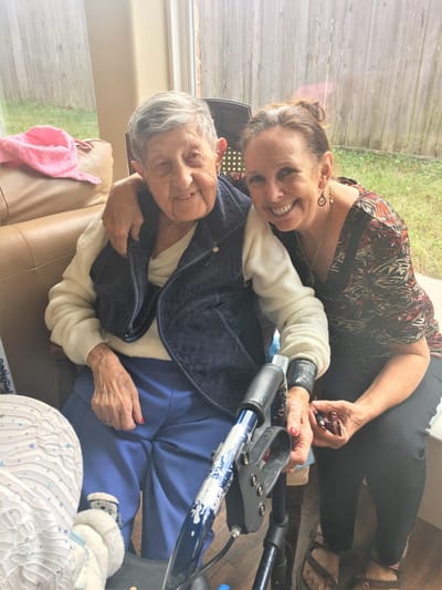 A caregiver and resident smiling together indoors