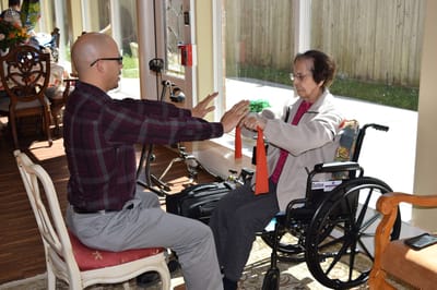 A staff member assisting a resident with therapy exercises