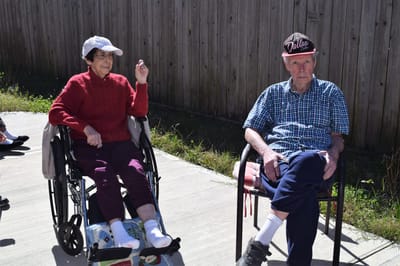Two residents enjoying time outdoors in a garden space
