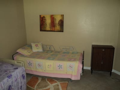 Private room in a senior care facility with a bed and decor