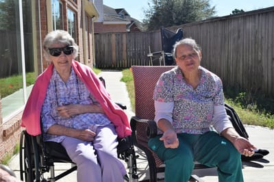 Two women enjoying time outdoors at a senior living facility