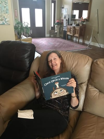 Resident reading a book in a cozy lounge area