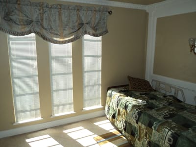 Brightly lit private room with a bed and window