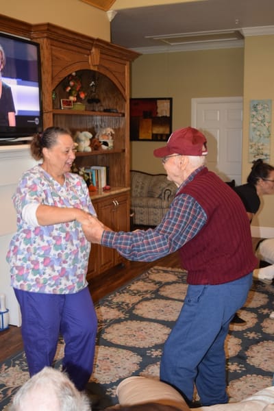 A caregiver dancing with a resident in a common area